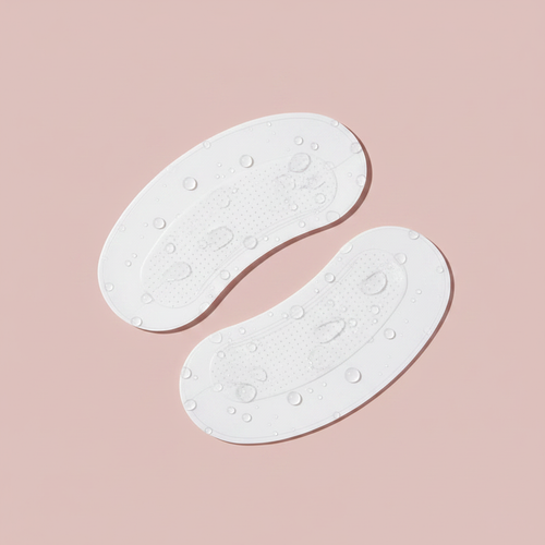 NuraDew microneedle eye patches on blush pink background